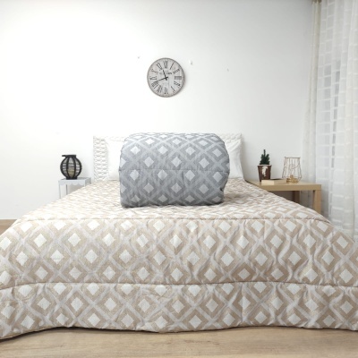 Colcha de cama bege com padr o geom trico e manta cinzenta sobre ela em quarto minimalista