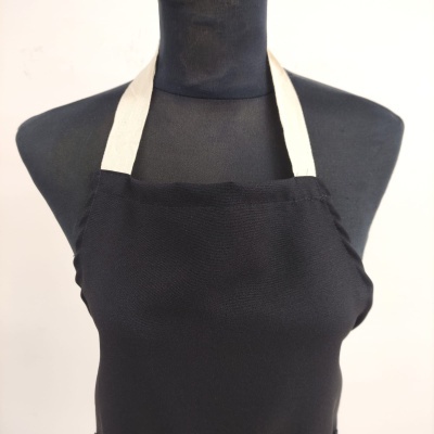 Avental preto com alças brancas num manequim preto
