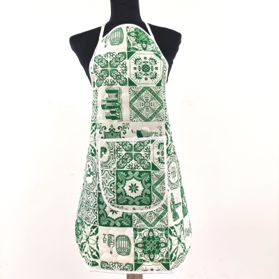 Avental de cozinha branco com padrão verde de azulejos, com bolso frontal, num manequim preto.