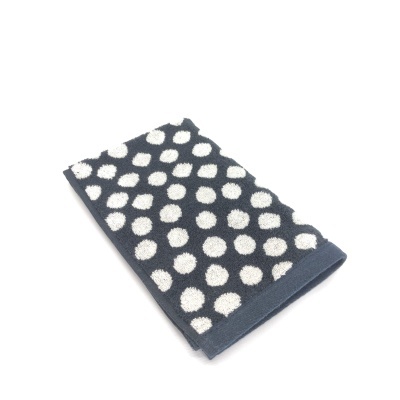 Toalha de mão azul escuro com bolinhas brancas dobrada