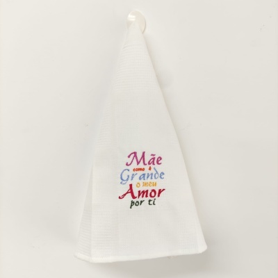Toalha branca com bordado colorido 'Mãe como é Grande o meu Amor por ti' pendurada na parede