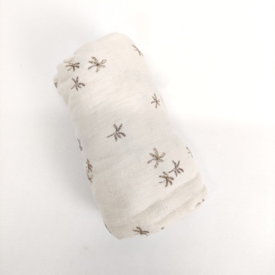 Tecido branco enrolado com padrões bordados castanhos