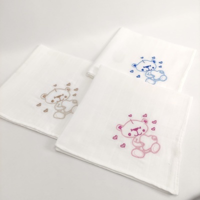 Três panos brancos com ursinhos bordados em castanho, azul e rosa com corações.