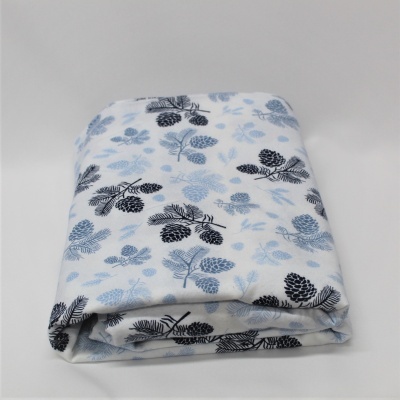 Manta dobrada com padrão de pinhas e folhas azul e preto