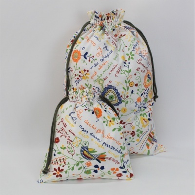 Dois sacos de tecido com cordões e estampas coloridas de flores e pássaros