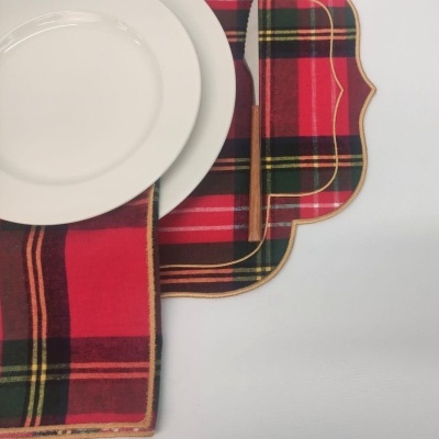 Conjunto de mesa com pratos brancos, guardanapo e caminho de mesa tartan vermelhos e faca com cabo de madeira