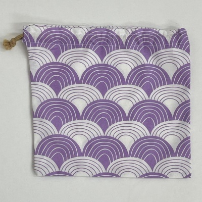 Saco de tecido com padrão de ondas roxas e brancas e fecho de cordão