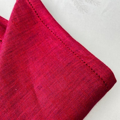 Pano vermelho com costura decorativa e padrão de folhas no fundo branco