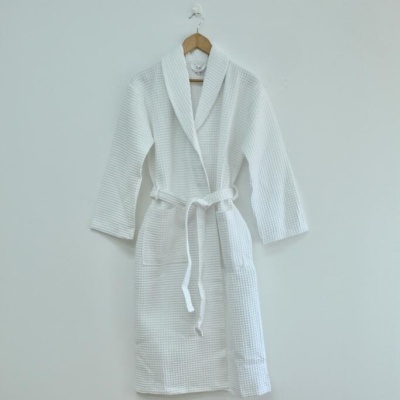 Robe branco com padrão waffle, cinto e bolsos pendurado em cabide de madeira