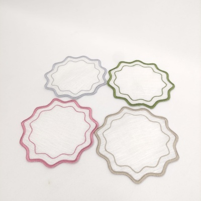 Individuais de mesa brancos com bordas coloridas onduladas, em rosa, bege, verde e cinzento