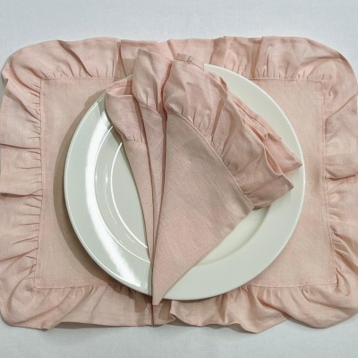 Suporte e guardanapo cor-de-rosa claro com prato branco em cima