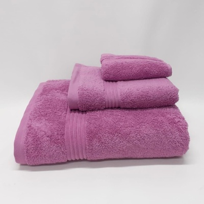 Conjunto de três toalhas cor de rosa empilhadas com bordas listradas