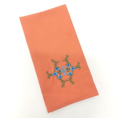 Pano de cozinha laranja com bordado de flores azuis