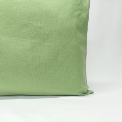 Almofada verde claro sobre superfície branca