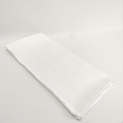 Toalha de mesa branca dobrada com padrão de quadrados muito discretos