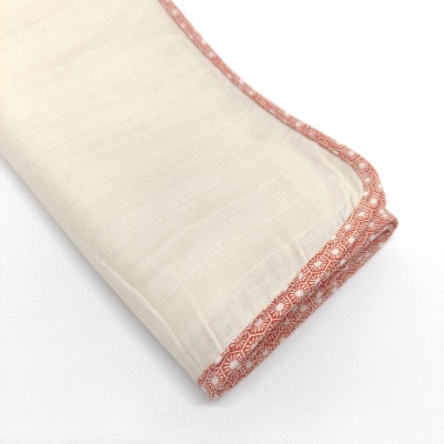 Toalha branca com borda terracota geométrica