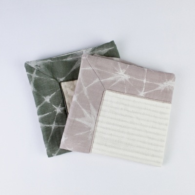 Dois porta-copos quadrados em tecido com padrões de estrelas e riscas