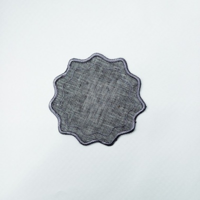 Aplique têxtil cinzento com contorno ondulado sobre fundo branco