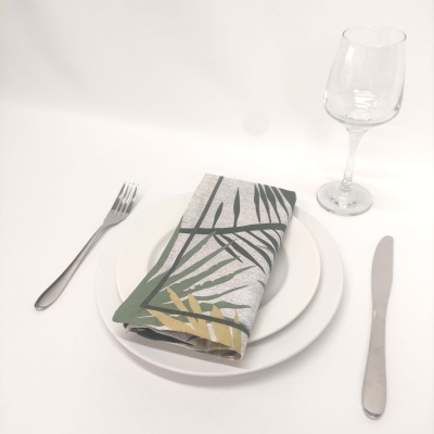Conjunto de pratos com guardanapo decorado e utensílios de mesa em fundo branco