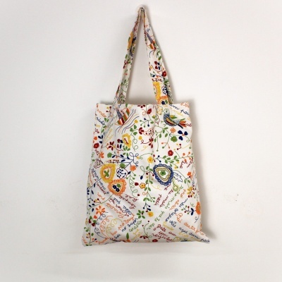 Saco de tecido branco com estampa floral colorida e texto manuscrito