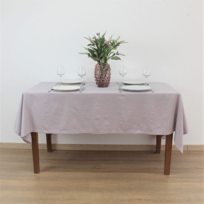 Mesa retangular com toalha rosa e decoração de planta no vaso em formato de abacaxi