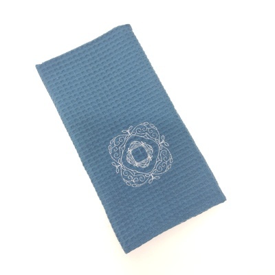 Toalha azul com bordado branco circular