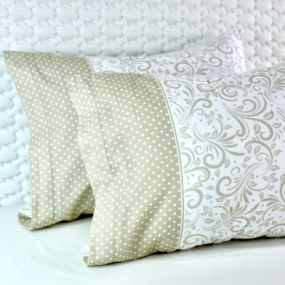 Duas almofadas retangulares com padrão bege e branco, uma com bolinhas e outra com desenhos florais.