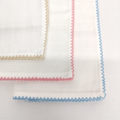 Três lenços brancos com bordas zig-zag coloridas