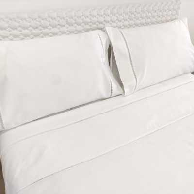 Jogo de cama branco com fronhas e lençol em tecido liso