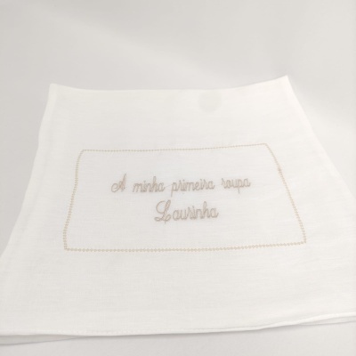 Toalha branca com bordado bege 'A minha primeira roupa Lounha'