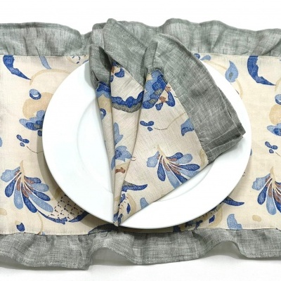 Conjunto de individuais e guardanapo de tecido com padrão floral azul e bege e borda cinza