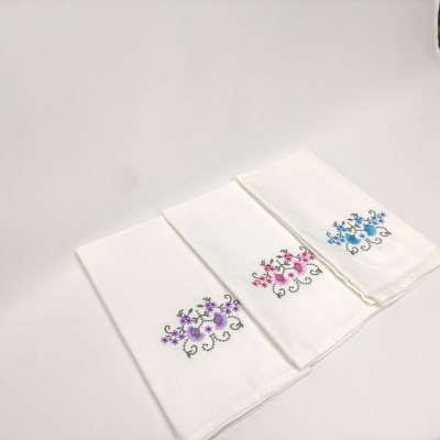 Três panos de cozinha brancos com bordados florais coloridos