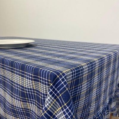 Toalha de mesa azul xadrez com prato branco em fundo neutro