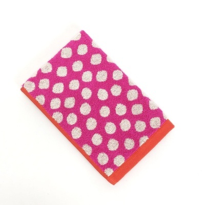 Toalha rosa com bolas brancas e borda laranja