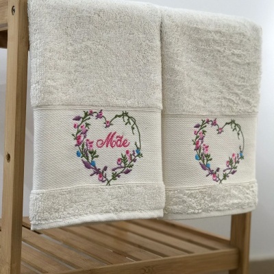 Toalhas de banho brancas com bordado floral e a palavra 