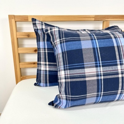 Almofadas xadrez azuis numa cama de madeira clara