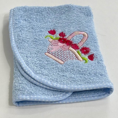 Toalha azul claro com bordado de cesta com flores vermelhas