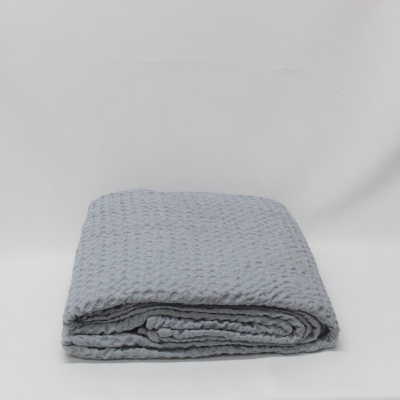Cobertor cinzento claro com padrão quadrado dobrado