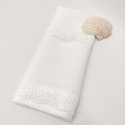 Toalha branca com renda e concha marítima