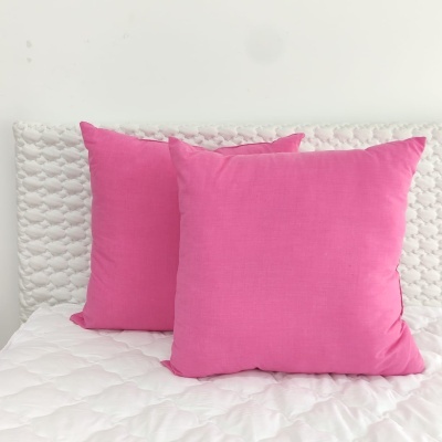 Dois almofadas cor-de-rosa sobre cama branca texturizada