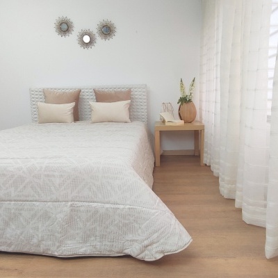 Quarto minimalista com cama branca e decoração neutra