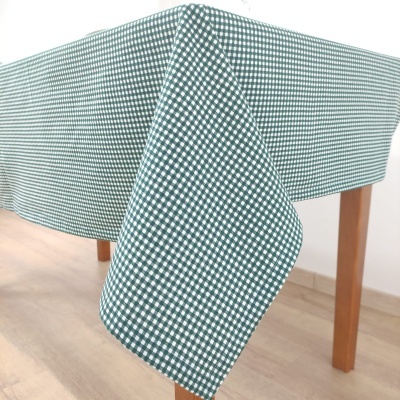Toalha de mesa retangular xadrez verde e branco sobre mesa de madeira