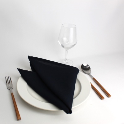 Conjunto de loiça com talheres de madeira, guardanapo preto e copo de vidro