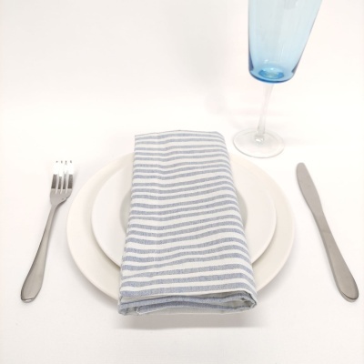 Conjunto de utensílios de mesa com pratos, guardanapo riscado e taça azul