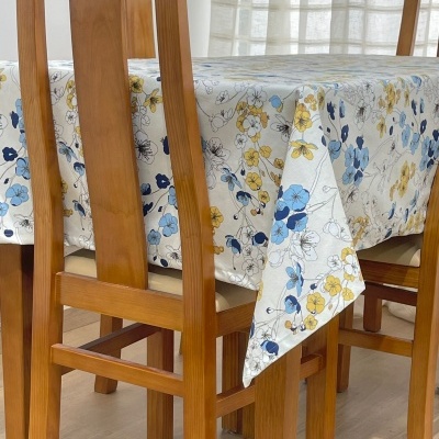 Mesa de jantar com toalha floral e cadeiras de madeira