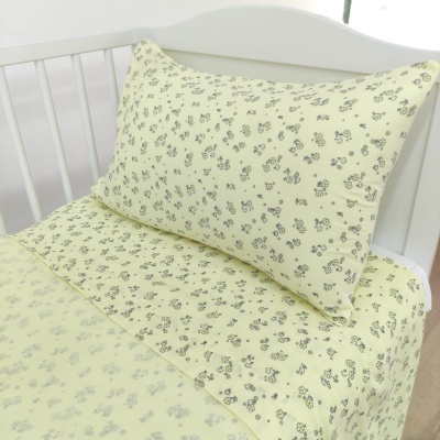 Conjunto de cama amarelo claro com padrão de pequenas flores pretas