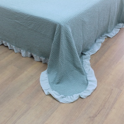 Colcha verde água com folhos brancos na borda sobre cama