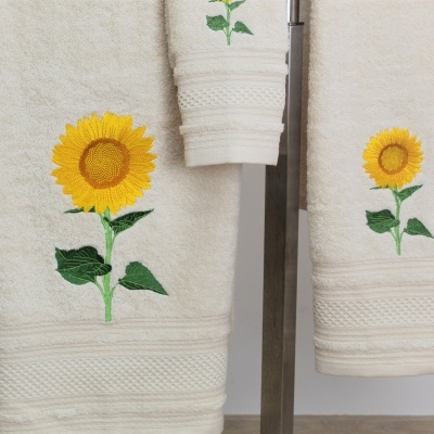 Toalhas bege claro com bordados de girassol amarelo