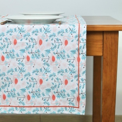 Toalha de mesa floral azul e coral em mesa de madeira