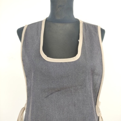 Avental cinza escuro com acabamento em bege claro num manequim preto
